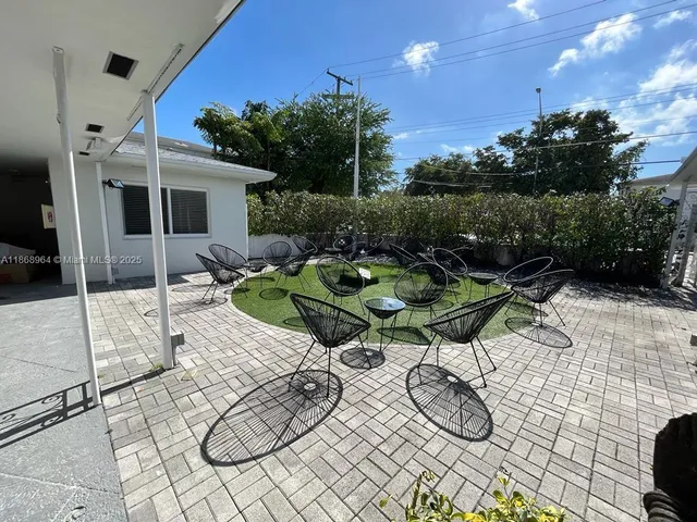 a backyard of a house with table and chairs
