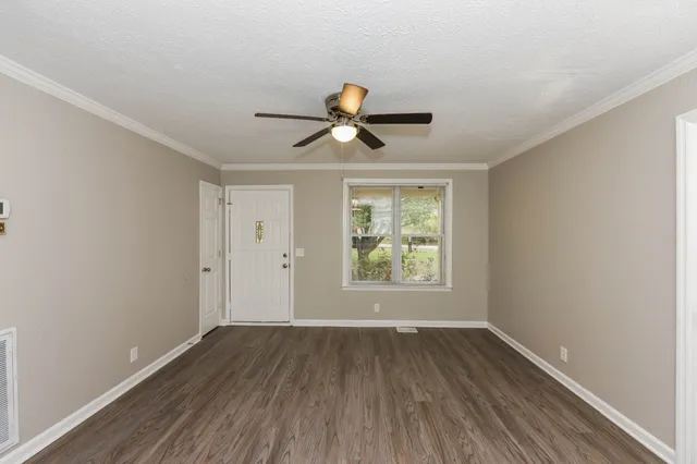 a view of a room with wooden floor and chandelier fan