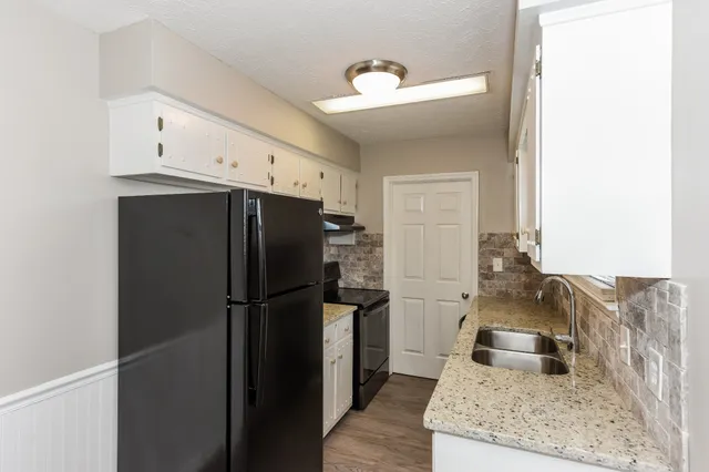 a kitchen with stainless steel appliances granite countertop a refrigerator and a sink