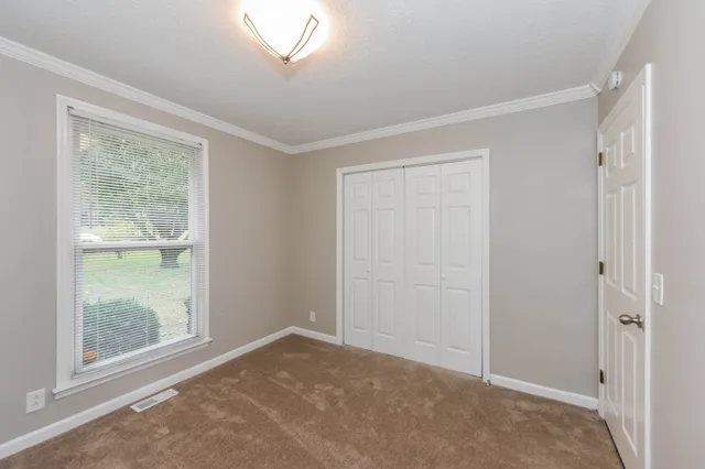 an empty room with windows and closet