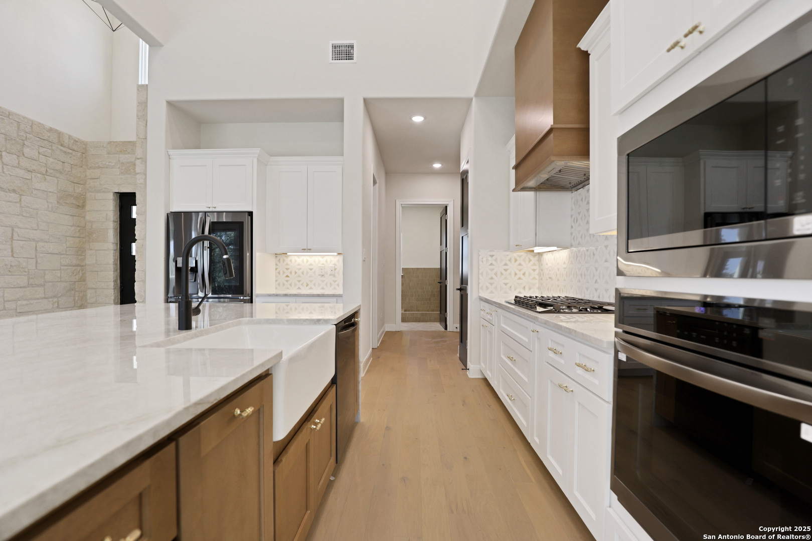 775 Maximino Ridge Bulverde, TX 78163 - Photo 16 of 41 a large kitchen with stainless steel appliances kitchen island granite countertop a stove a sink and a microwave