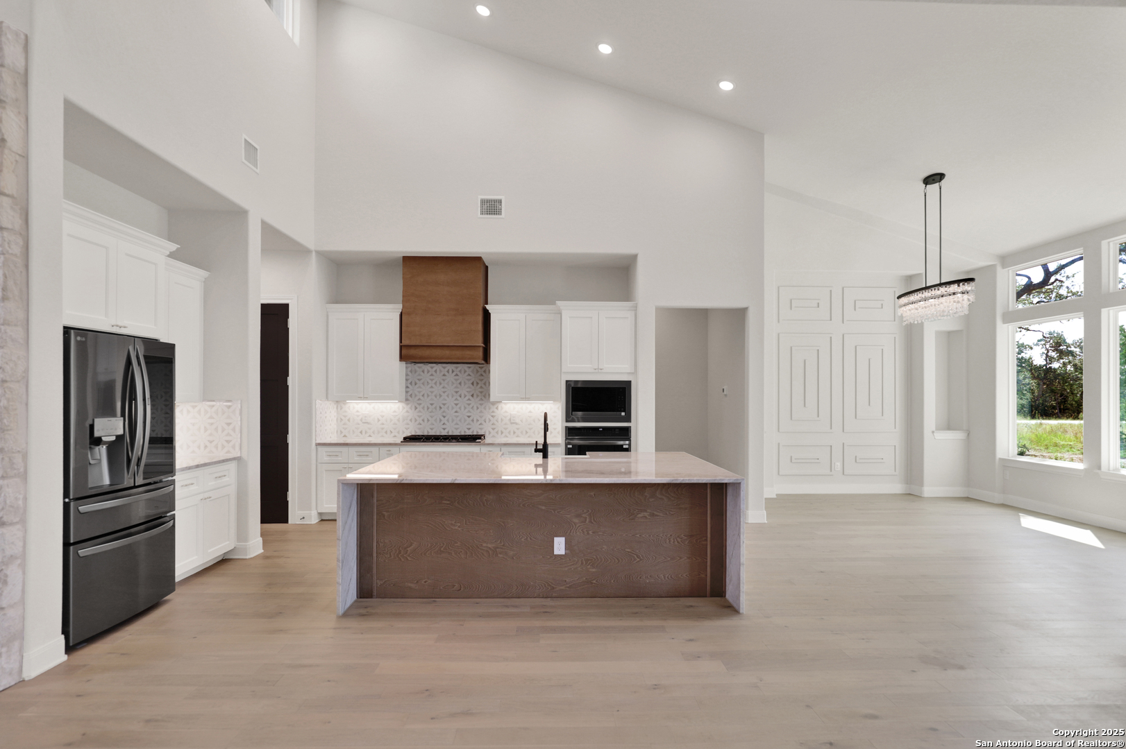 775 Maximino Ridge Bulverde, TX 78163 - Photo 7 of 41 a large kitchen with stainless steel appliances a large counter top a stove a refrigerator and a sink