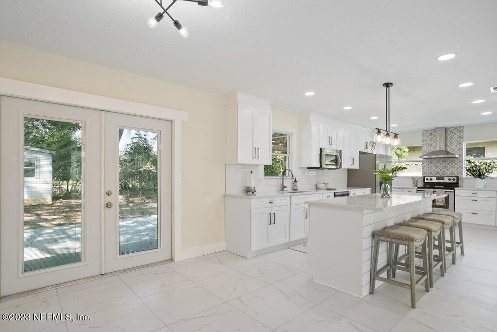 2746 Sam Road Jacksonville, FL 32216 - Photo 14 of 44 a kitchen with white cabinets and chairs