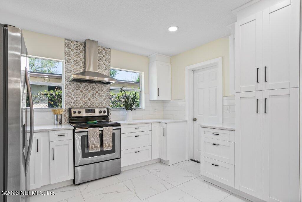 2746 Sam Road Jacksonville, FL 32216 - Photo 18 of 44 a kitchen with white cabinets and appliances