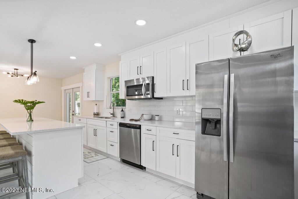 2746 Sam Road Jacksonville, FL 32216 - Photo 20 of 44 a kitchen with a sink stainless steel appliances and white cabinets