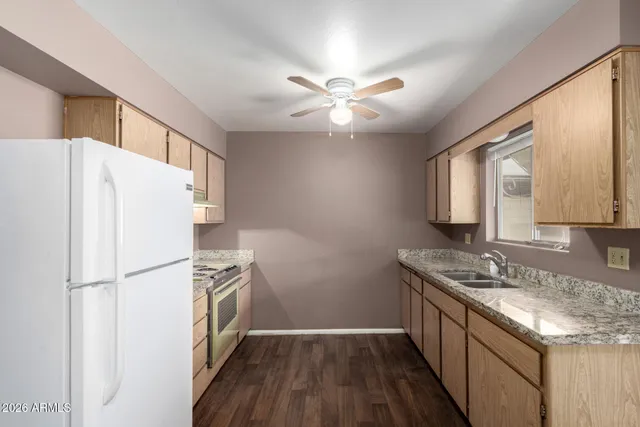 a kitchen with granite countertop white cabinets and white appliances