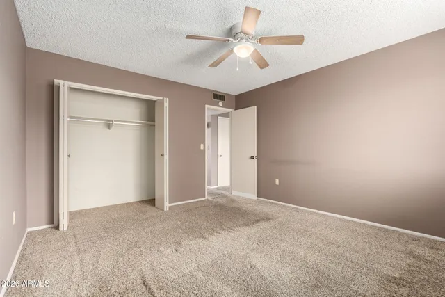 an empty room with fan and entrance