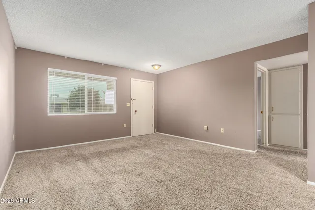 a view of an empty room with window and closet area