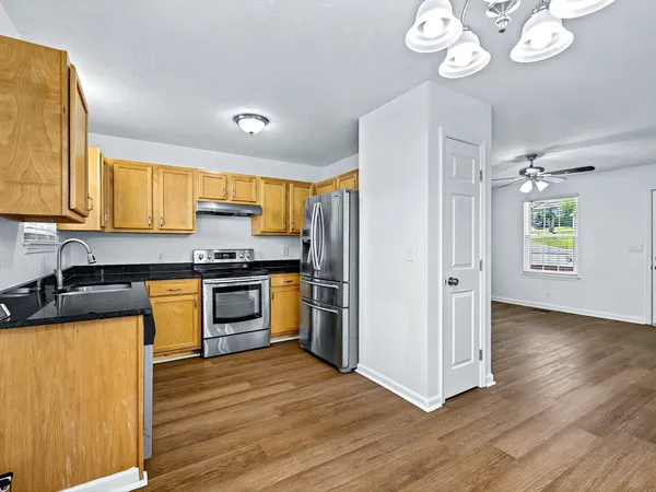a kitchen with granite countertop stainless steel appliances and wooden cabinets
