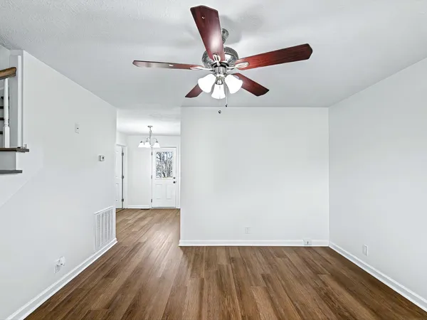a view of an empty room with window and wooden floor