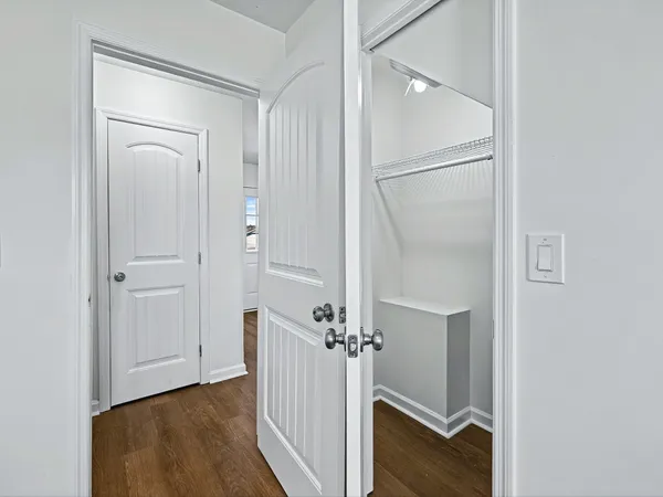 a view of a hallway with closet and wooden floor