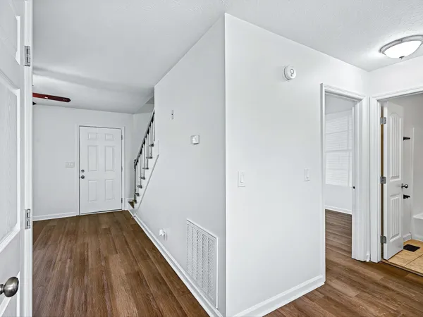 a view of a hallway with wooden floor and entryway