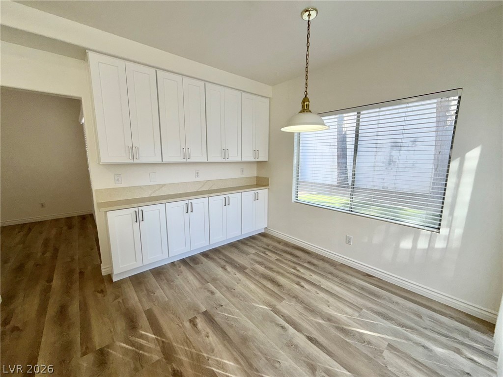 9729 Trail Rider Drive Las Vegas, NV 89117 - Photo 6 of 26 Clean lines and light wood-look flooring enhance this flexible room, featuring generous cabinet storage and a sun-filled window.