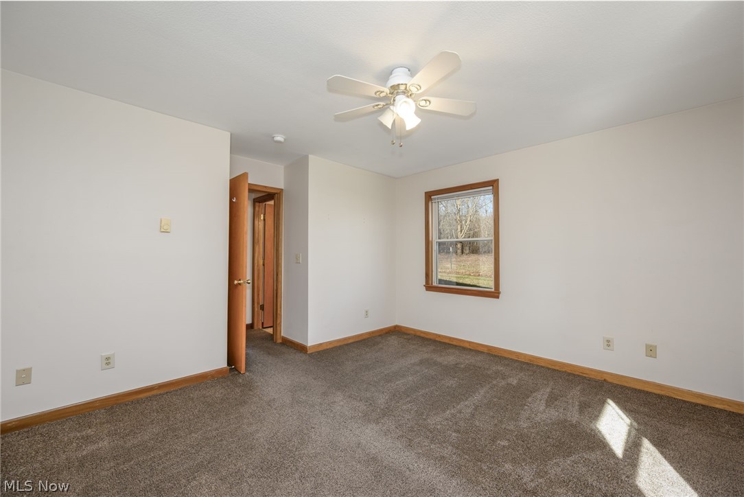 8464-8446 Tallmadge Road Diamond, OH 44412 - Photo 20 of 39 Empty room featuring dark carpet and ceiling fan