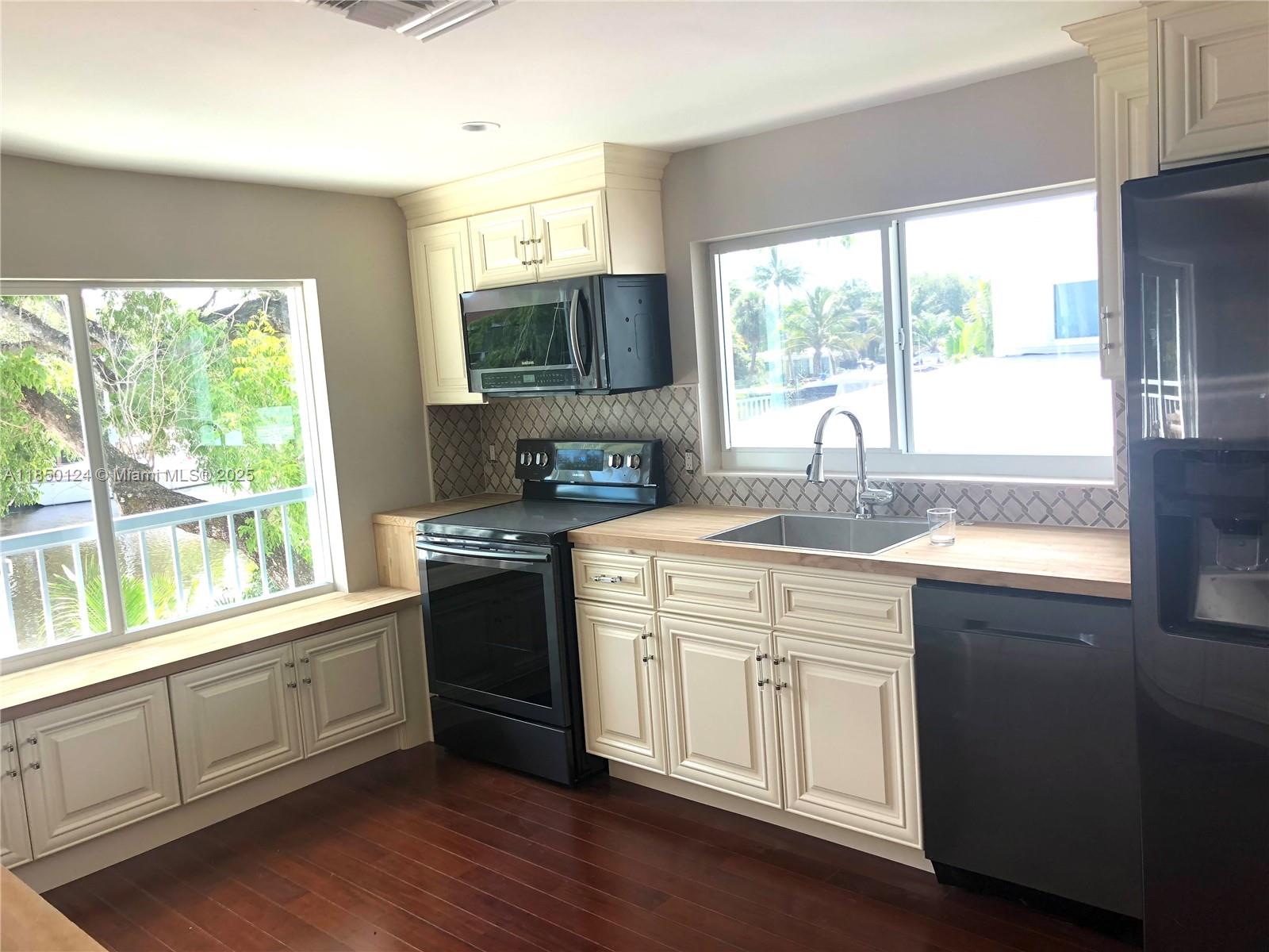 1524 Argyle Drive, Unit 1 Fort Lauderdale, FL 33312 - Photo 25 of 38 a kitchen with a sink wooden floor and a stove top oven