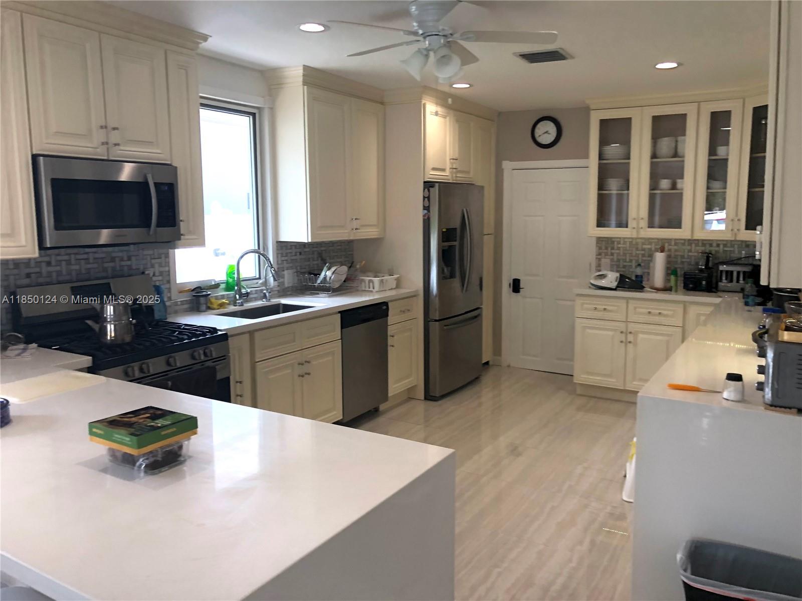 1524 Argyle Drive, Unit 1 Fort Lauderdale, FL 33312 - Photo 10 of 38 a kitchen with stainless steel appliances a sink a stove a refrigerator a center island and a stove