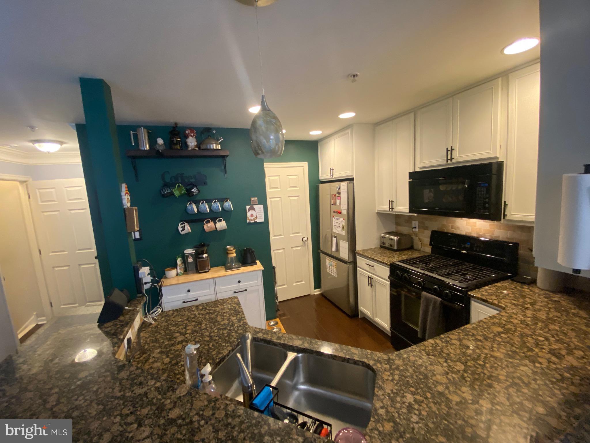 219 Flagstone Road, Unit 6 Chester Springs, PA 19425 - Photo 7 of 15 a kitchen with stainless steel appliances kitchen island granite countertop a refrigerator and a stove top oven