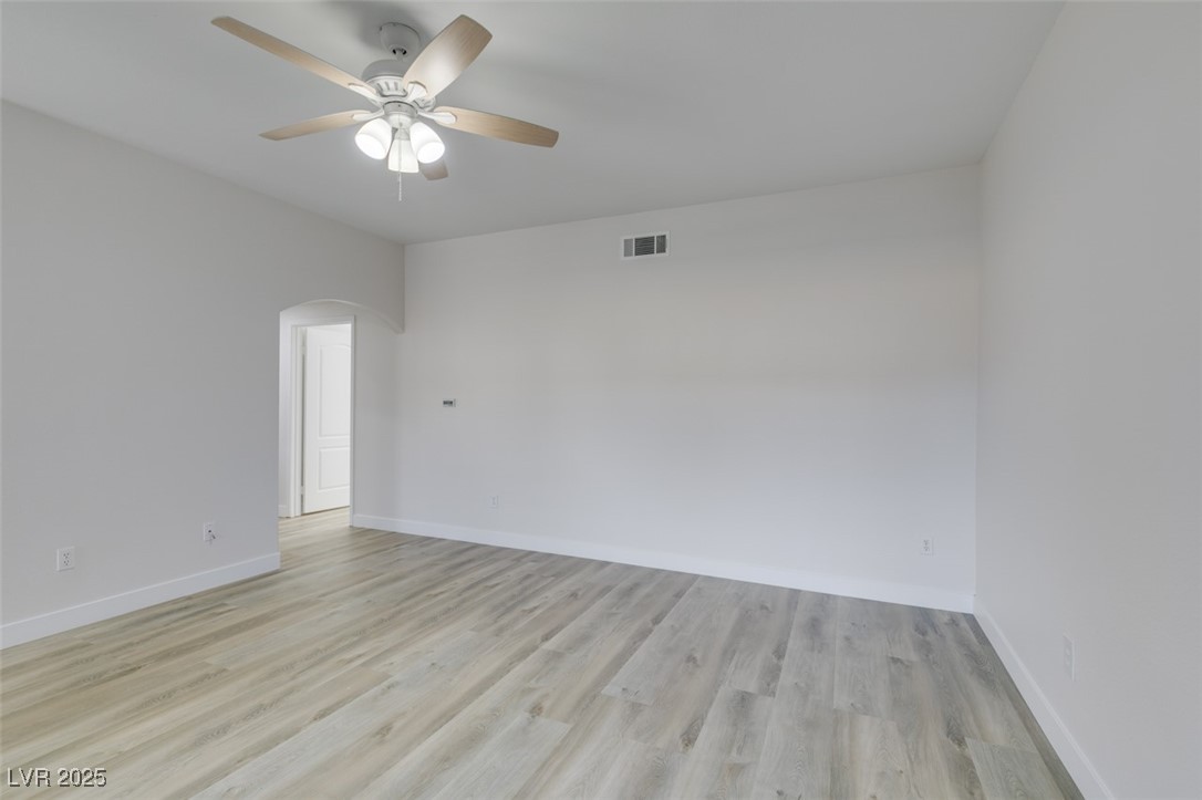 5525 West Flamingo Road, Unit 1028 Las Vegas, NV 89103 - Photo 16 of 42 Empty room with light wood-style flooring, arched walkways, and a ceiling fan