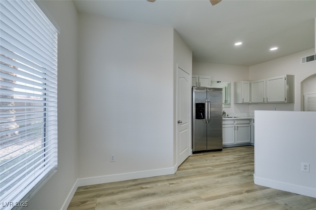 5525 West Flamingo Road, Unit 1028 Las Vegas, NV 89103 - Photo 23 of 42 Kitchen with stainless steel refrigerator with ice dispenser, light wood-style floors, light countertops, plenty of natural light, and recessed lighting