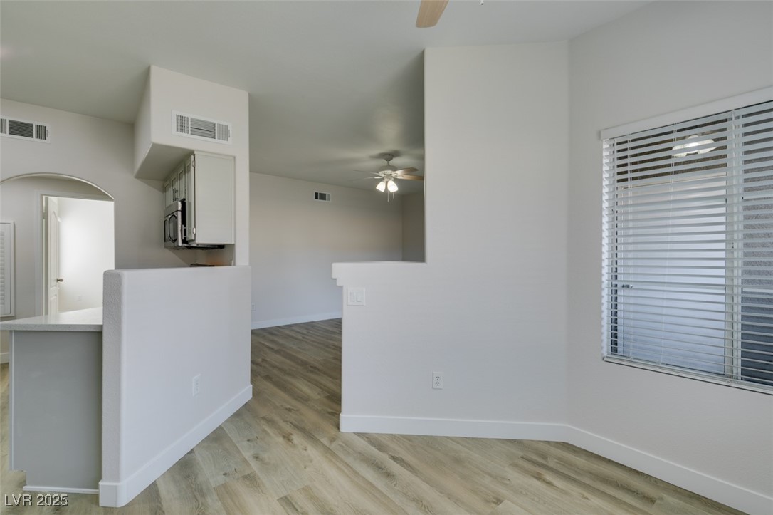 5525 West Flamingo Road, Unit 1028 Las Vegas, NV 89103 - Photo 25 of 42 Unfurnished room with light wood-style floors, arched walkways, and a ceiling fan