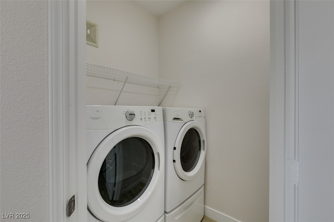 5525 West Flamingo Road, Unit 1028 Las Vegas, NV 89103 - Photo 34 of 42 Laundry area with washer and clothes dryer and a textured wall