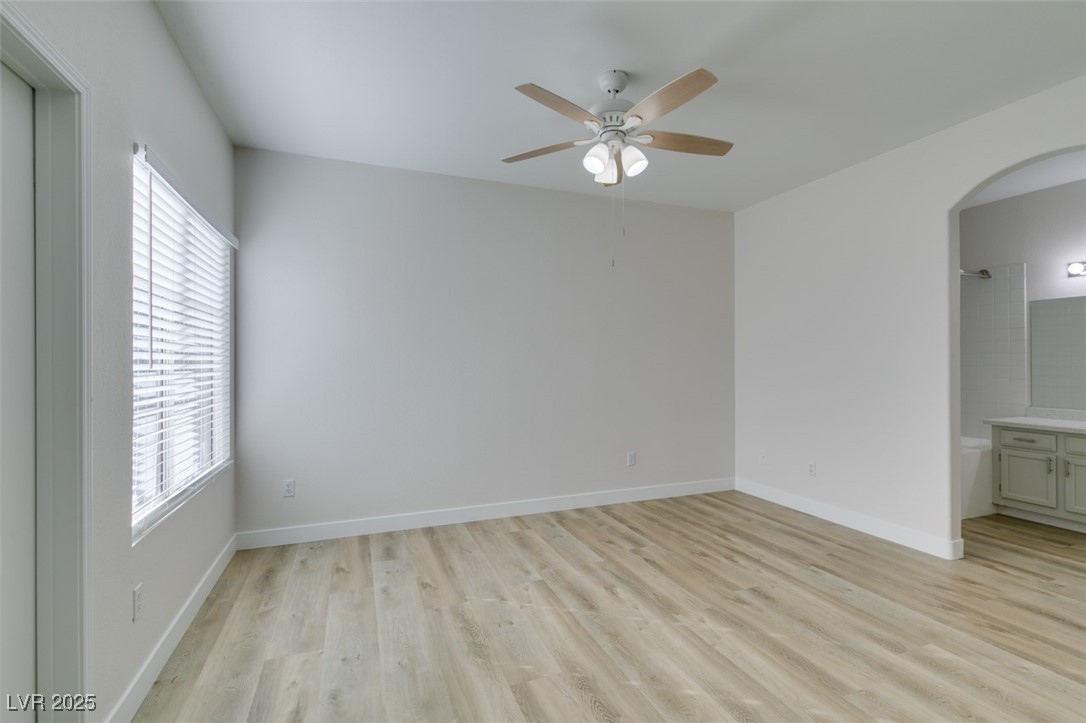 5525 West Flamingo Road, Unit 1028 Las Vegas, NV 89103 - Photo 35 of 42 Empty room with light wood-type flooring, arched walkways, and ceiling fan