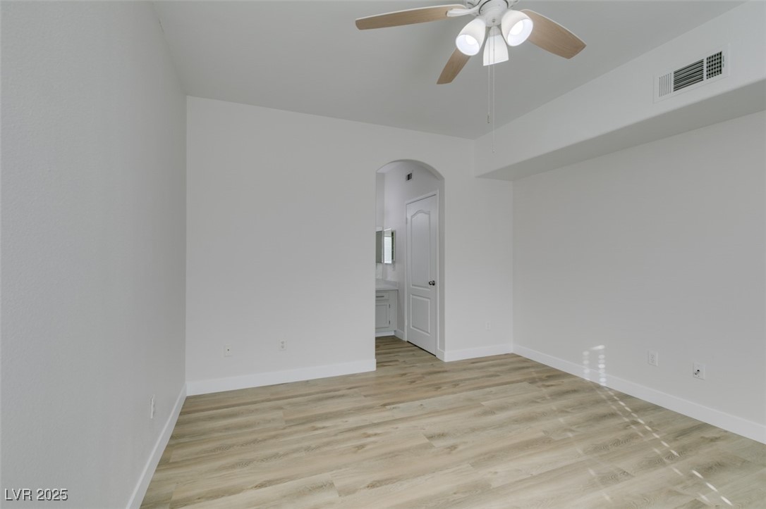 5525 West Flamingo Road, Unit 1028 Las Vegas, NV 89103 - Photo 37 of 42 Unfurnished room featuring arched walkways, light wood-style flooring, and a ceiling fan