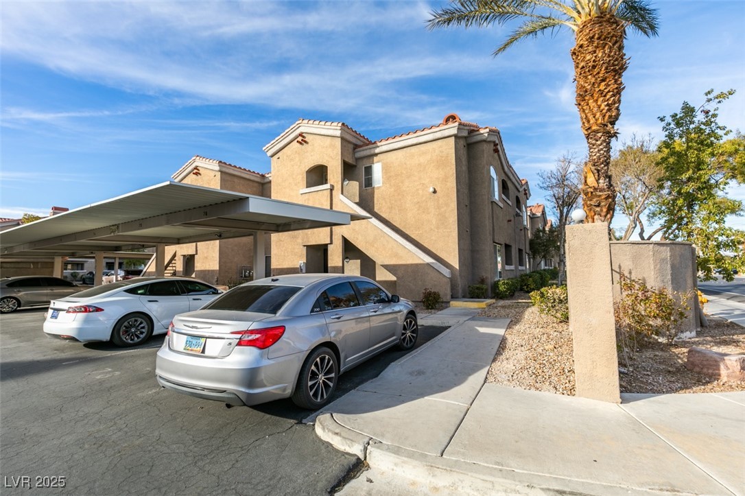 5525 West Flamingo Road, Unit 1028 Las Vegas, NV 89103 - Photo 5 of 42 View of front of house featuring stucco siding, a tiled roof, and covered parking