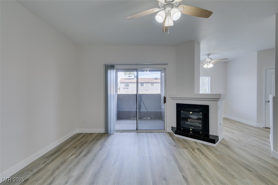 5525 West Flamingo Road, Unit 1028 Las Vegas, NV 89103 - Photo 9 of 42 Unfurnished living room with a fireplace and light wood-type flooring