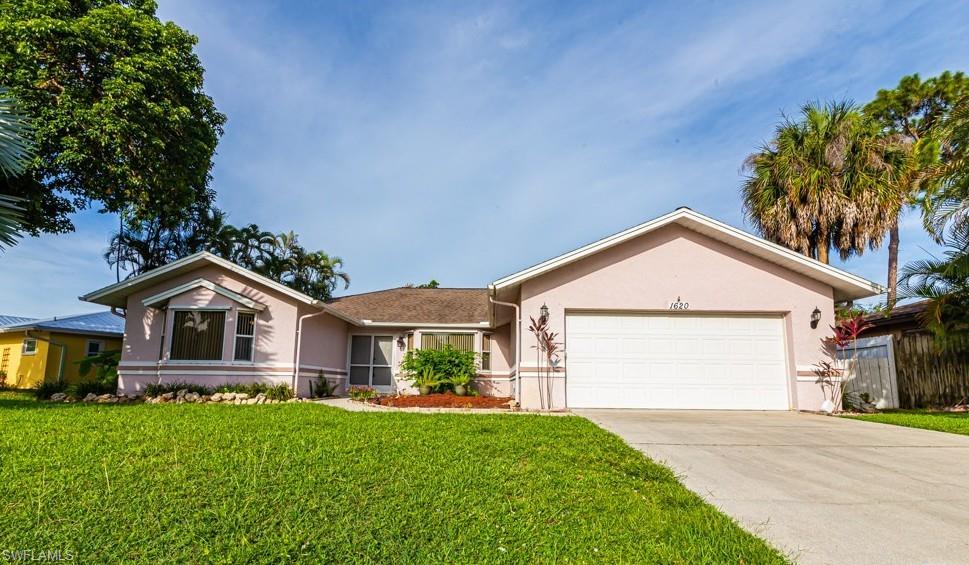 1620 Forest Lakes Boulevard Naples, FL 34105 - Photo 1 of 27 a front view of a house with a yard and porch