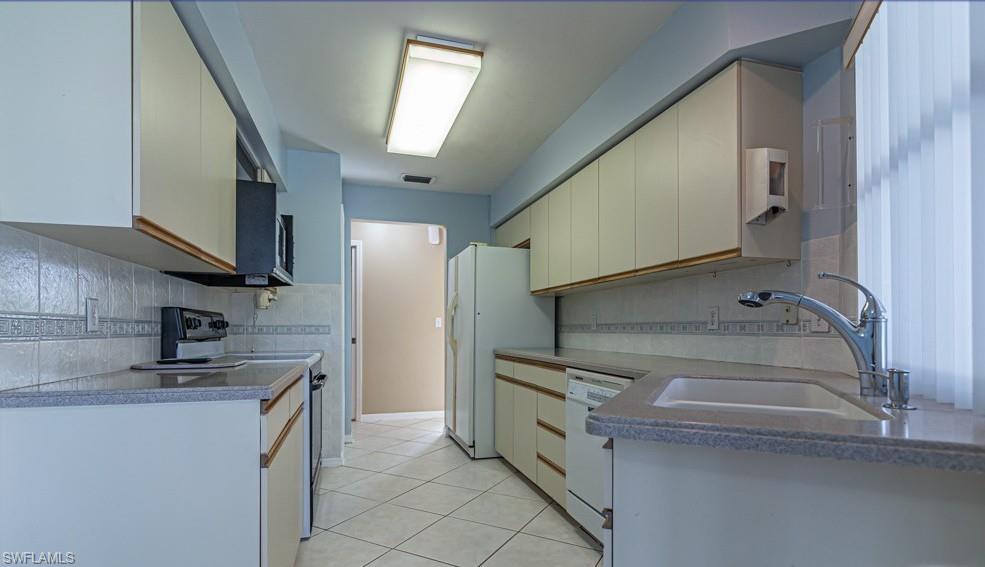 1620 Forest Lakes Boulevard Naples, FL 34105 - Photo 13 of 27 a kitchen that has a sink and a stove