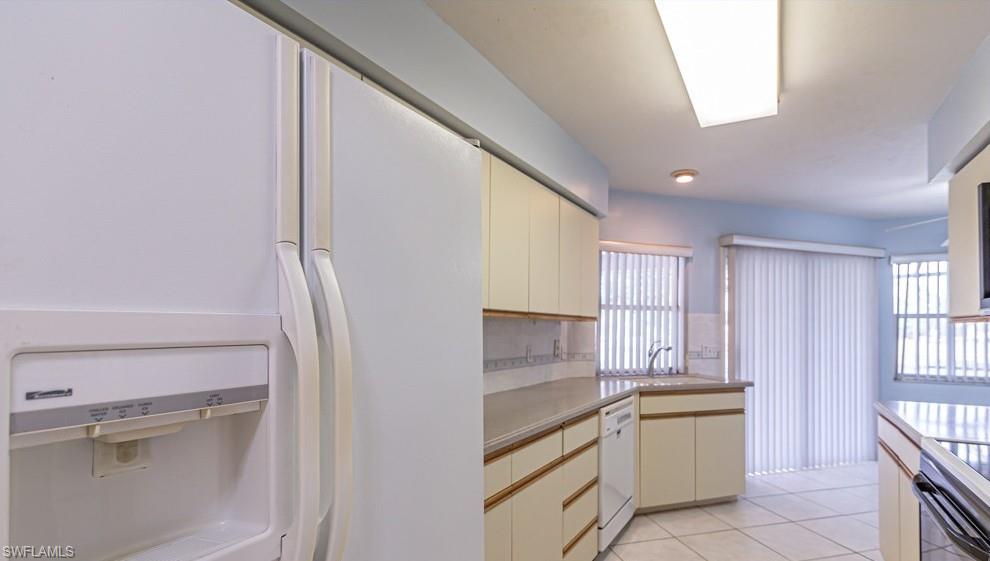 1620 Forest Lakes Boulevard Naples, FL 34105 - Photo 14 of 27 a kitchen with granite countertop white cabinets and white appliances