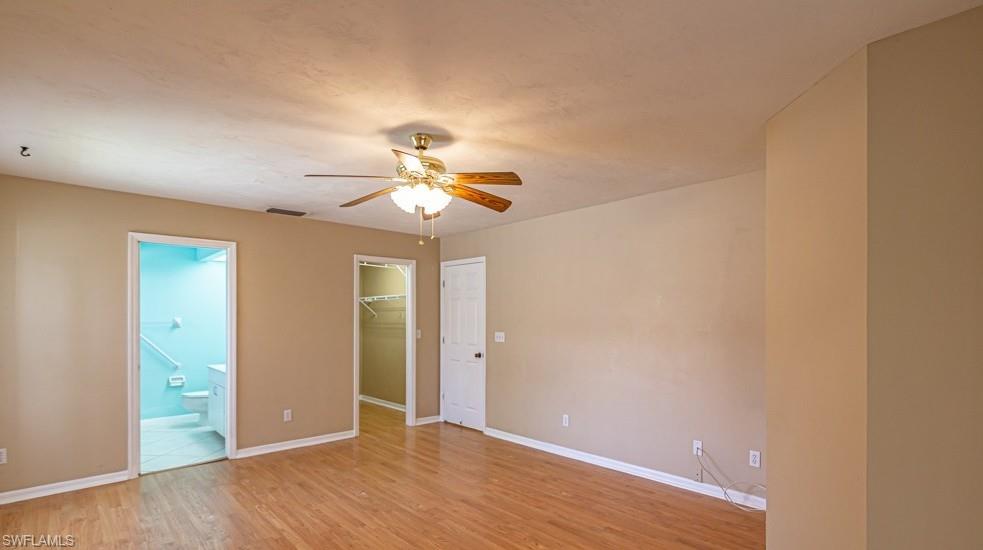 1620 Forest Lakes Boulevard Naples, FL 34105 - Photo 18 of 27 wooden floor in an empty room with a chandelier fan