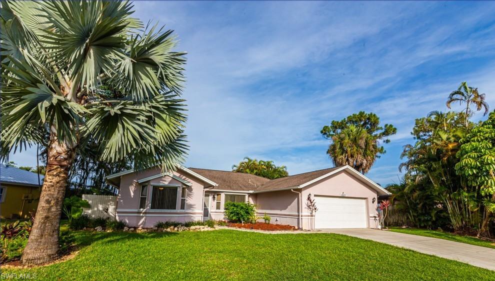 1620 Forest Lakes Boulevard Naples, FL 34105 - Photo 2 of 27 a front view of a house with a garden
