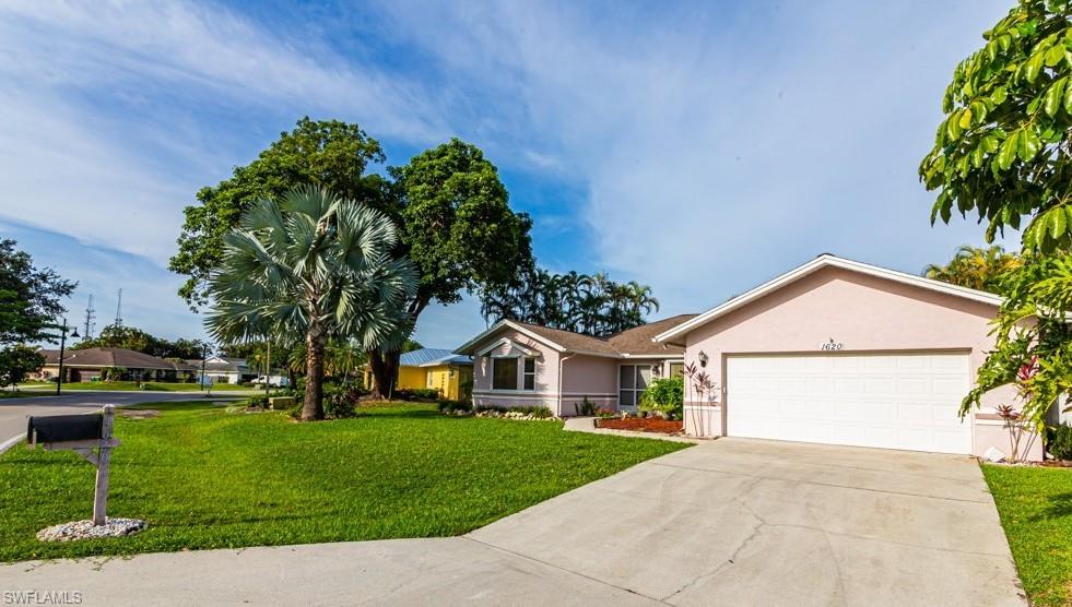 1620 Forest Lakes Boulevard Naples, FL 34105 - Photo 3 of 27 a front view of a house with a yard and garage