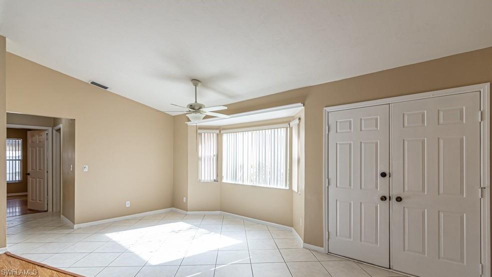 1620 Forest Lakes Boulevard Naples, FL 34105 - Photo 4 of 27 a view of an empty room with window and chandelier fan