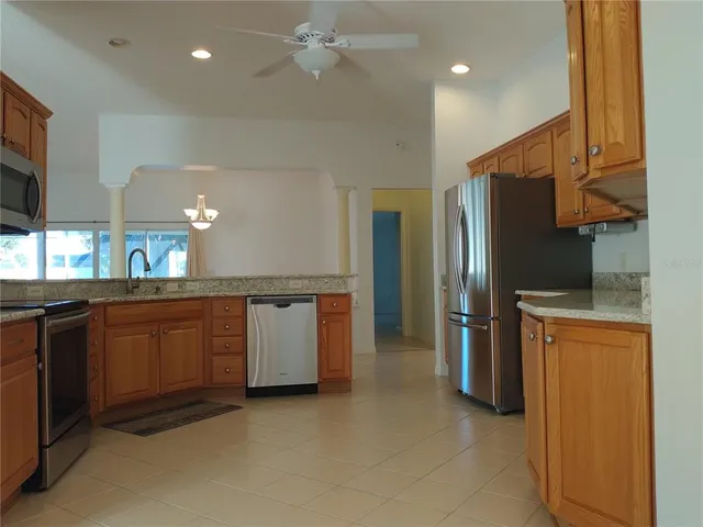 a kitchen with stainless steel appliances granite countertop a refrigerator and a sink