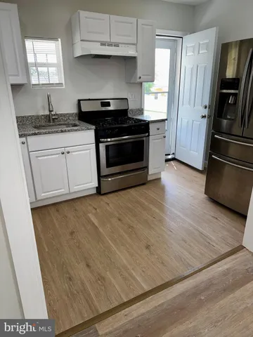 a kitchen with granite countertop white cabinets and stainless steel appliances