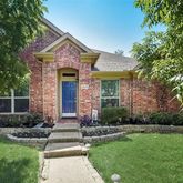 a front view of a house with a yard and a tree