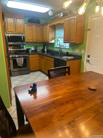 a kitchen with stainless steel appliances granite countertop a sink window and cabinets