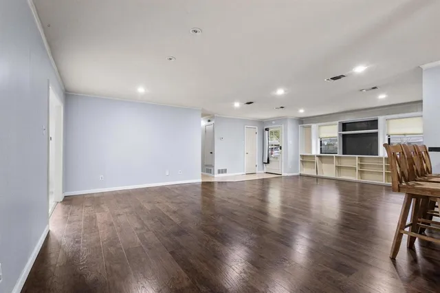 a view of empty room with wooden floor and floor to ceiling window