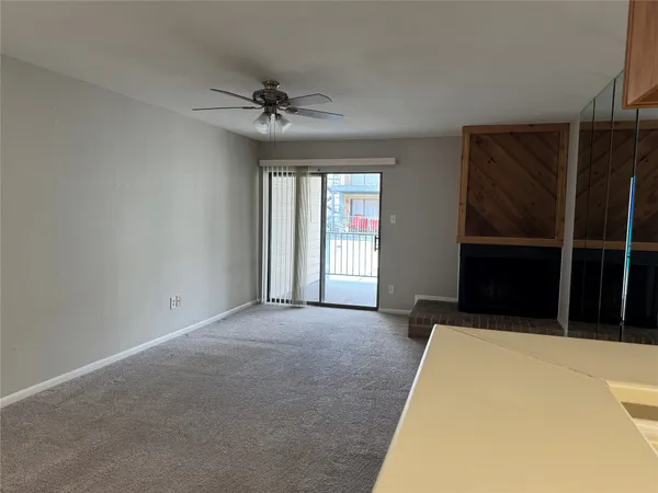 a view of a kitchen with refrigerator and white walls