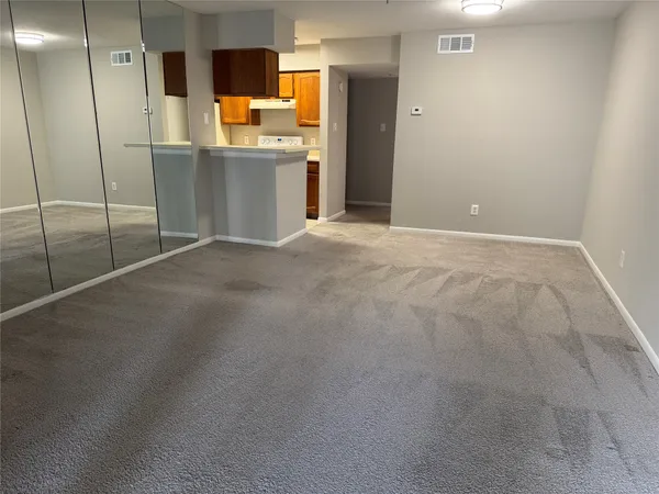a view of an empty room with a fireplace and a window