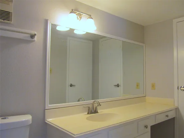 an empty room with a chandelier fan and windows