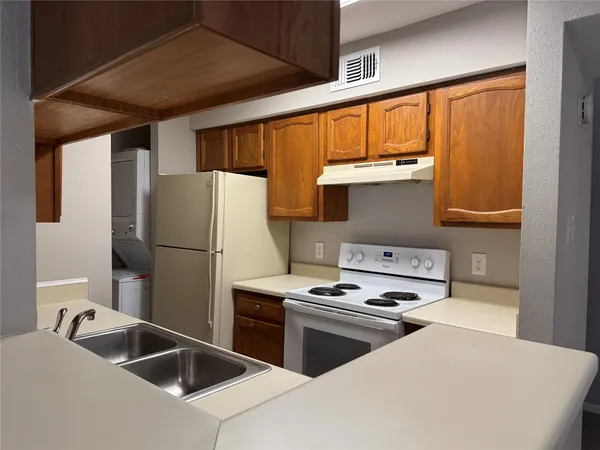 a kitchen with a sink cabinets and a refrigerator