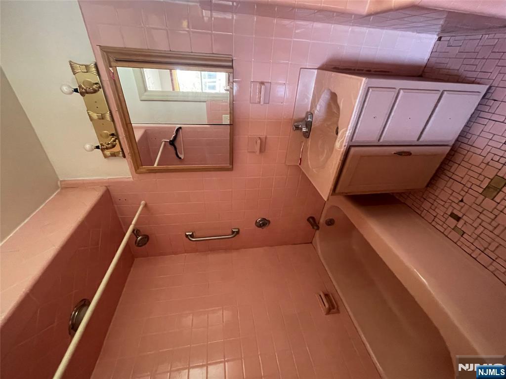 71 Passaic Street, Unit 2 Passaic, NJ 07055 - Photo 11 of 11 a bathroom with a tub sink and mirror