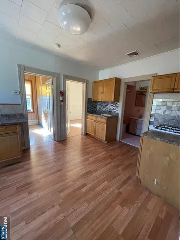a living room with stainless steel appliances granite countertop furniture wooden floor and a fireplace