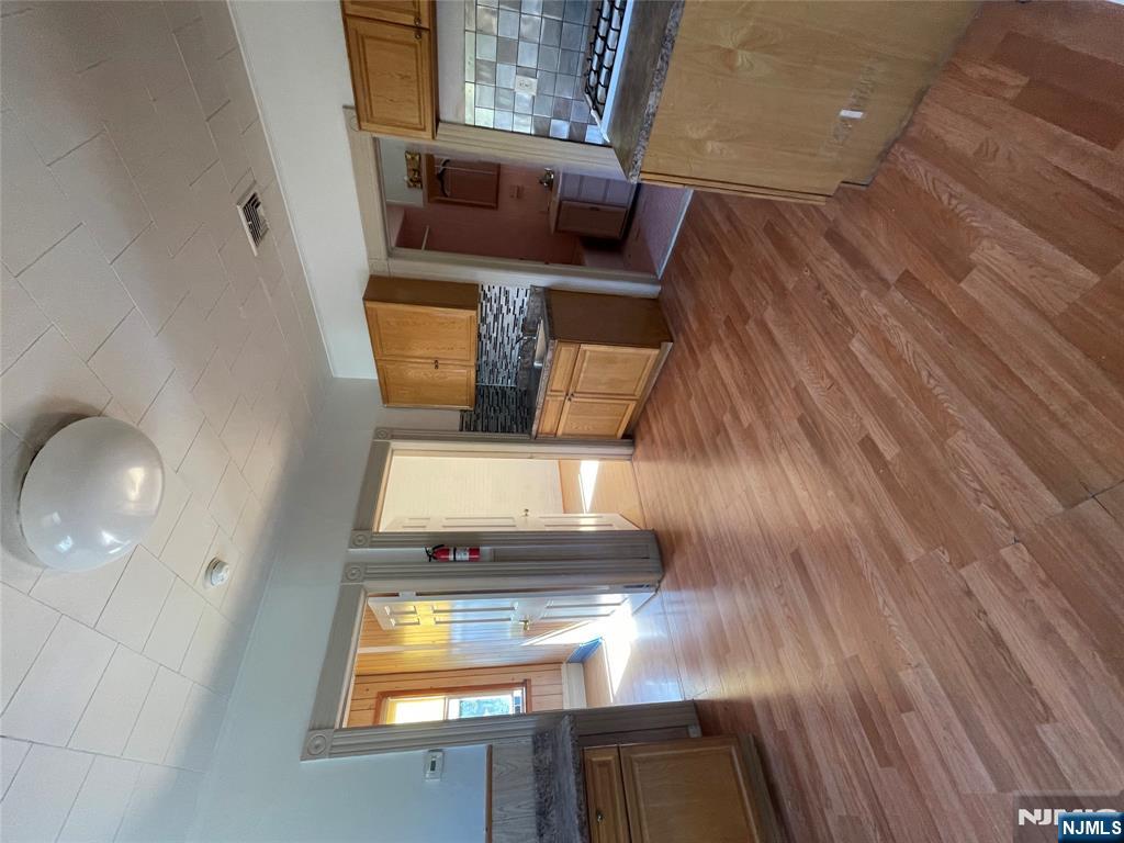 71 Passaic Street, Unit 2 Passaic, NJ 07055 - Photo 2 of 11 a living room with stainless steel appliances granite countertop furniture wooden floor and a fireplace