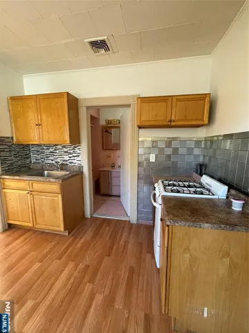 a kitchen with granite countertop a stove and a wooden floors