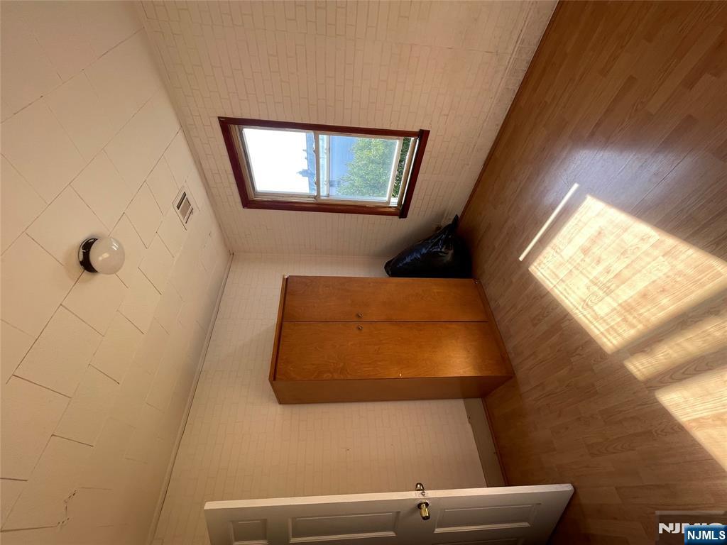 71 Passaic Street, Unit 2 Passaic, NJ 07055 - Photo 7 of 11 an empty room with wooden floor and windows